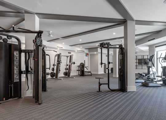 A spacious gym with a variety of equipment including treadmills, weights, and exercise machines.