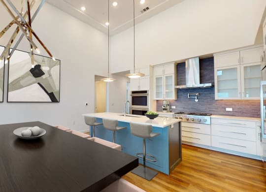 a kitchen and dining room with a black dining table and a blue kitchen