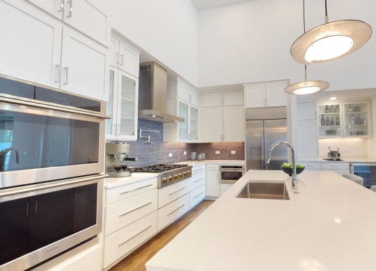 a large kitchen with a white counter top and a sink