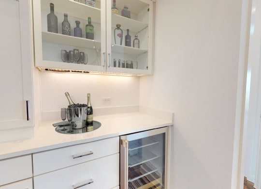 a small kitchen with white cabinets and white counter tops and a white counter top refrigerator