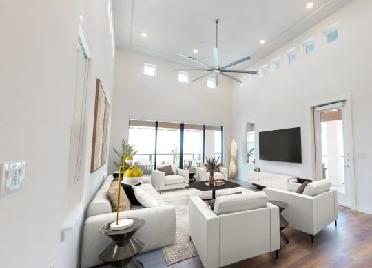 a living room with white couches and chairs and a tv