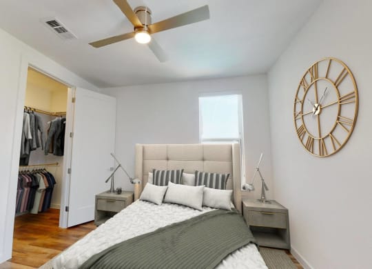 a bedroom with a bed and a large clock on the wall