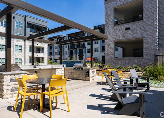 a patio with tables and chairs and a grill at the axis at princeton yards