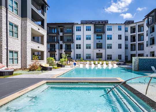 a swimming pool with an apartment building in the background