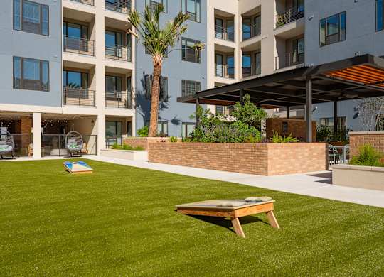 a lawn with a picnic table in front of an apartment building