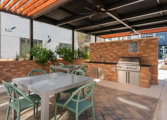 a patio with a table and chairs and an outdoor kitchen