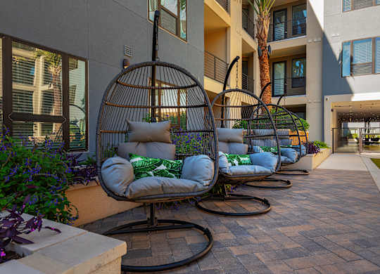 a row of swinging chairs in a courtyard