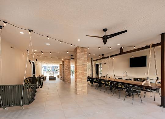 a dining room with a long table and chairs and a ceiling fan