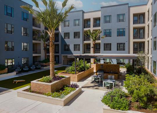 an outdoor courtyard with tables and chairs in an apartment building