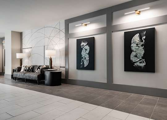 a lobby with a couch and paintings on the wall