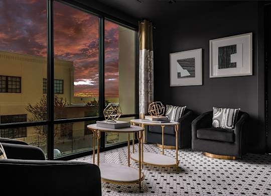 a living room with black walls and a large window