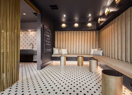 a seating area with a bench and a sink in the background