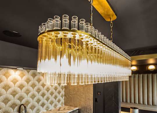 a chandelier made of champagne glasses hangs from the ceiling