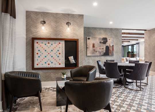 a room with a table and chairs and a quilt on the wall