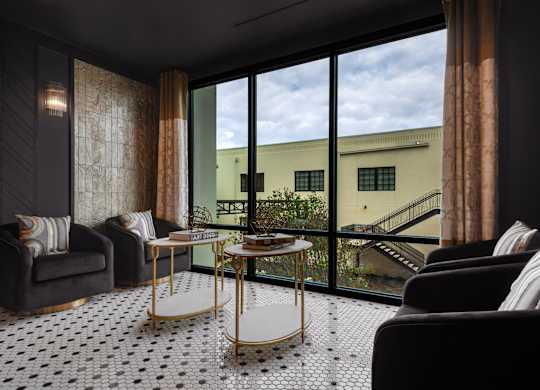 a living room with a large window and a black and white tile floor