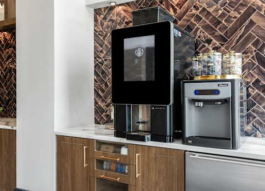 a kitchen with a coffee machine and a refrigerator