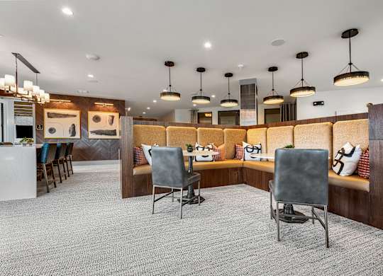 a seating area with chairs and a bar in the middle of a room