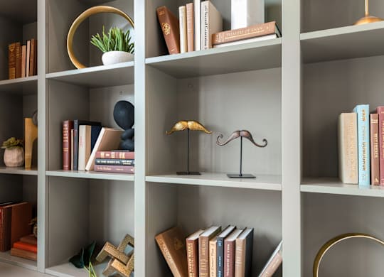 a bookcase with books and a lamp