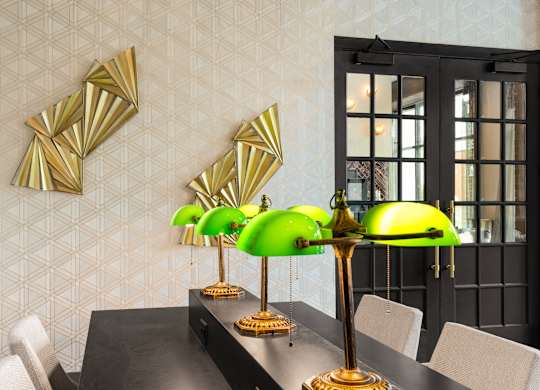 a dining room with a black dining table and green lamps
