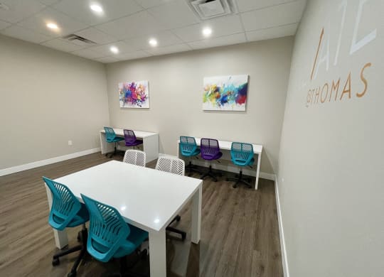 a conference room with a white table and blue chairs