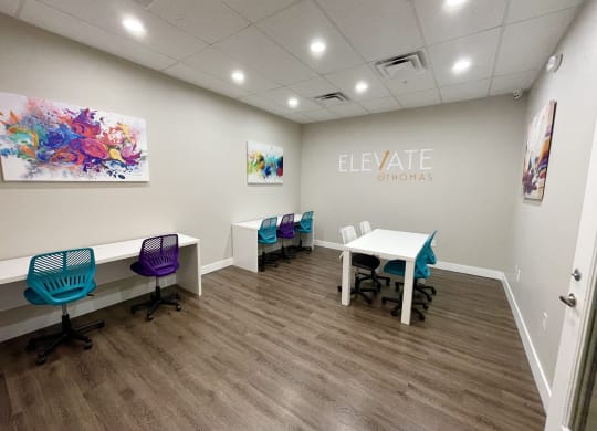 a room with a table and chairs and a sign that says elevate gyms on the wall