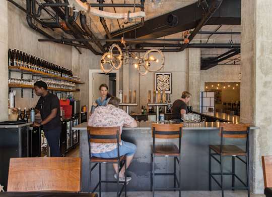 Industrial style bar with exposed ceiling beams at THE'68 Apartments, San Antonio, 78205