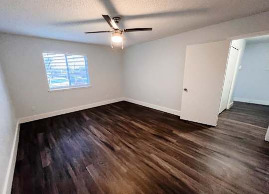 an empty living room with wooden floors and a ceiling fan at Northchase,Texas