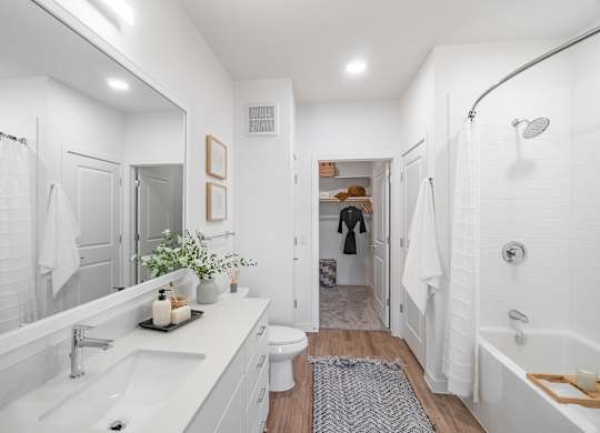 A white bathroom with a white tub and sink.
