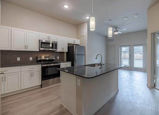Modern kitchen with black countertop and island at Emilia Apartments, Boerne, 78006
