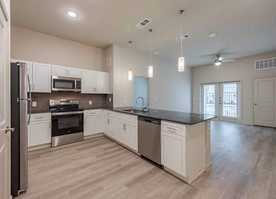 Open concept kitchen with island and pendant lighting at Emilia Apartments, Boerne, Texas