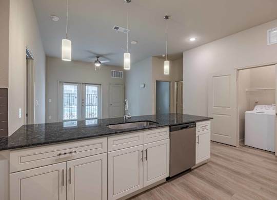 Modern kitchen with dark granite countertops at Emilia Apartments, Boerne