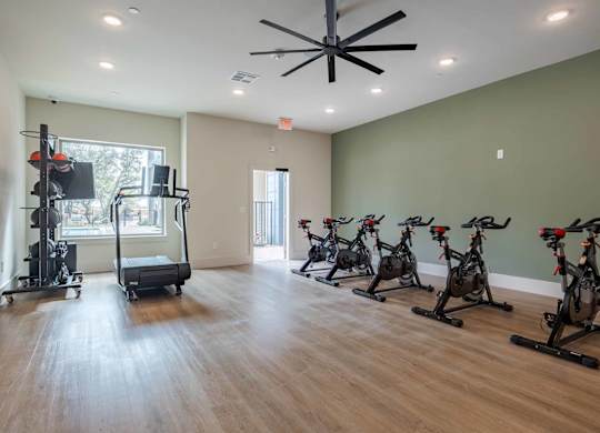 Fitness center with spin bikes and equipment at Emilia Apartments, Texas