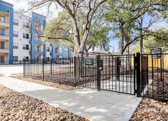 Fenced dog park with entry gate at Emilia Apartments, Boerne