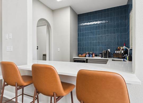 Three orange chairs are placed around a white table.