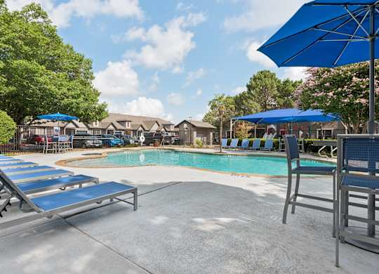 A pool area with sun loungers and umbrellas.