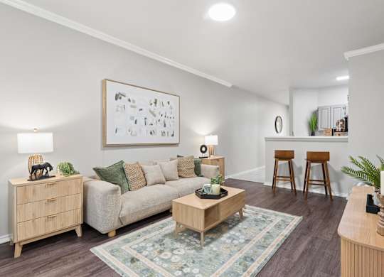 A living room with a couch, a coffee table, and a painting on the wall.