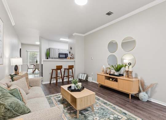 A living room with a couch, coffee table, and a large mirror on the wall.