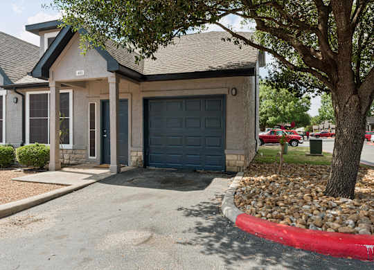A house with a grey roof and a blue garage door.