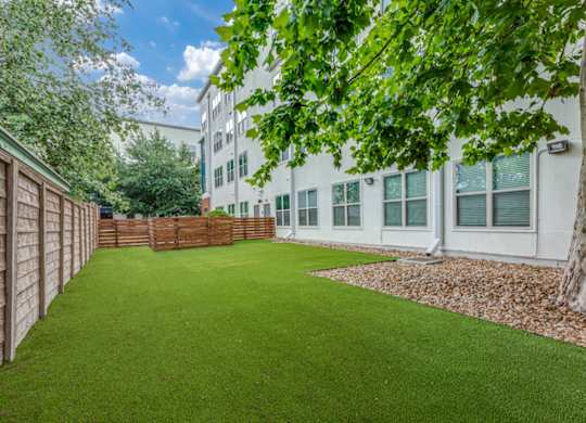 A white building with a green lawn in front.