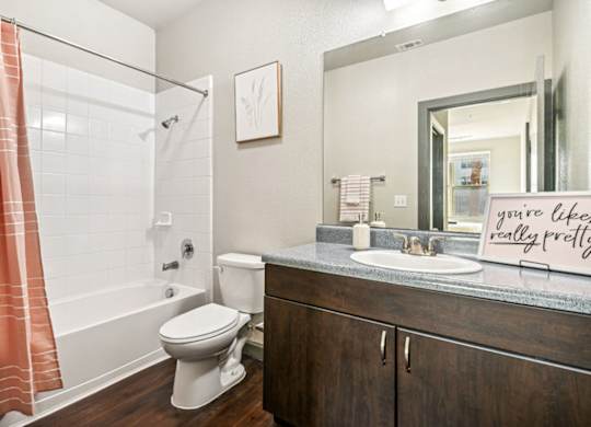 A bathroom with a toilet, sink, and shower.