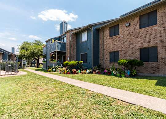 A brick building with a green lawn in front.