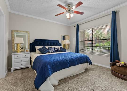 Bedroom with blue bedding and ceiling fan at Melia Medical Center Apartments, Houston, TX 77054