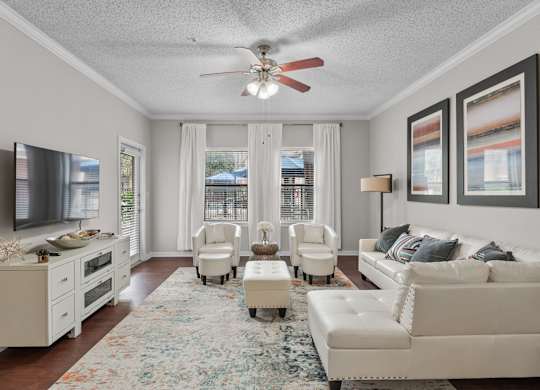 Living room with white furniture and ceiling fan at Melia Medical Center Apartments, Houston, TX