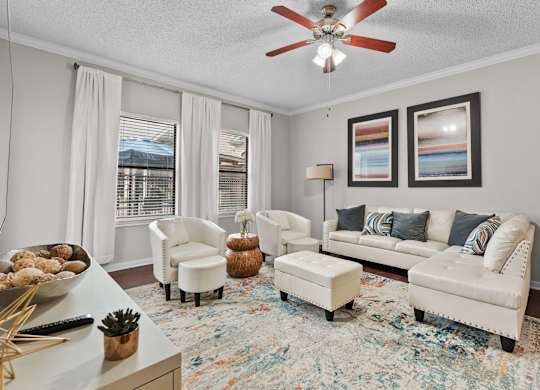 Modern living room with ceiling fan and sectional sofa at Melia Medical Center Apartments, Houston, Texas