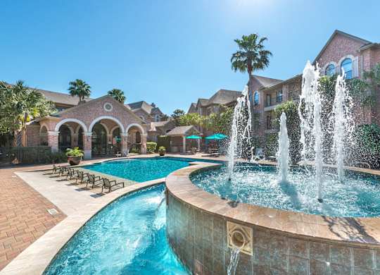 Resort style pool with fountains and lounge chairs at Melia Medical Center Apartments, Houston