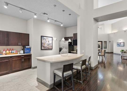 Community kitchen with island seating and wood floors at Melia Medical Center Apartments, Houston