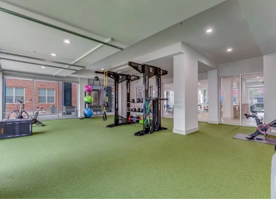 A gym with a green floor and various exercise equipment.