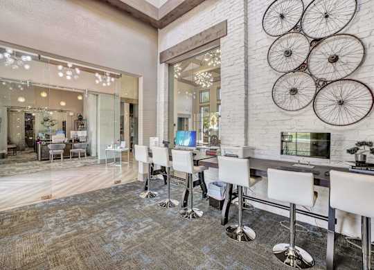 A white bar with stools is in front of a wall with bicycle decorations.