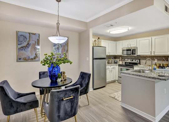 A kitchen with a table and chairs and a refrigerator.