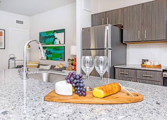 Kitchen island with wine glasses and cheese board at Sienna at Westover Hills Apartments, Texas